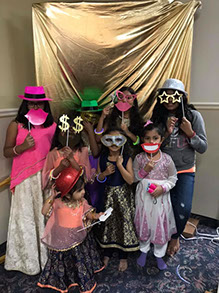 Children with masks at a celebration. Fresno County Gujarati Samaj